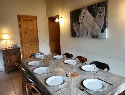 a wooden table with plates and wine glasses on it at C11, 72m2, 3 bedrooms, next to the ski lift in Samoëns