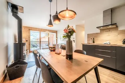 a kitchen and dining room with a wooden table and chairs at Apartment Opale Megève - by EMERALD STAY in Megève