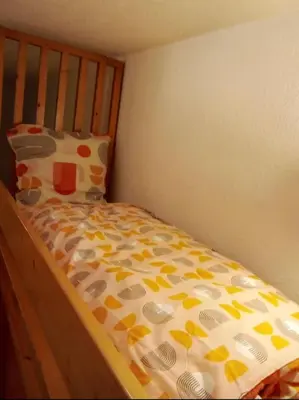 a bed with a comforter and a pillow on it at Aiguille du midi in Chamonix-Mont-Blanc