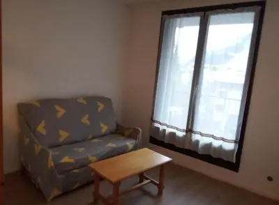 a living room with a chair and a table and a window at Aiguille du midi in Chamonix-Mont-Blanc