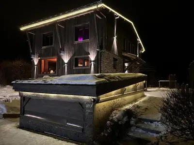 a house with lights on it in the snow at Chalet 8 Etoiles in Chamonix-Mont-Blanc