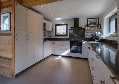 a large kitchen with white cabinets and a large island at Chalet 8 Etoiles in Chamonix-Mont-Blanc