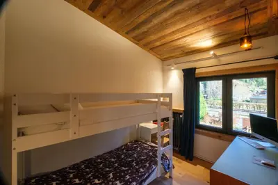 a bunk bed in a room with a desk and a window at Chalet 8 Etoiles in Chamonix-Mont-Blanc