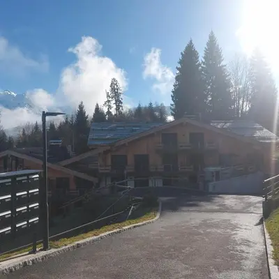 a large building with a fence in front of it at Appartement T2 de Standing Neuf 6-8 personnes avec Balcon et Jardinet au Pied des Pistes à Combloux in Combloux