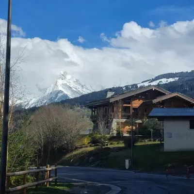 a ski lodge with a snow covered mountain in the background at Appartement T2 de Standing Neuf 6-8 personnes avec Balcon et Jardinet au Pied des Pistes à Combloux in Combloux