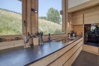 a kitchen with a counter with a sink and a window at Chalet familial vue MontBlanc in Saint-Gervais-les-Bains