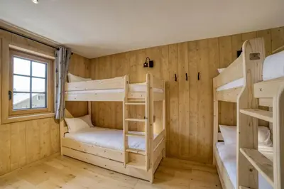 a room with four bunk beds and a window at Chalet familial vue MontBlanc in Saint-Gervais-les-Bains