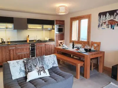 a living room with a couch and a table in a kitchen at Saskya 5 65m2, 2 bedrooms, next to the ski lift in Samoëns