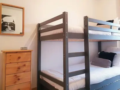 a bedroom with two bunk beds and a dresser at Saskya 5 65m2, 2 bedrooms, next to the ski lift in Samoëns