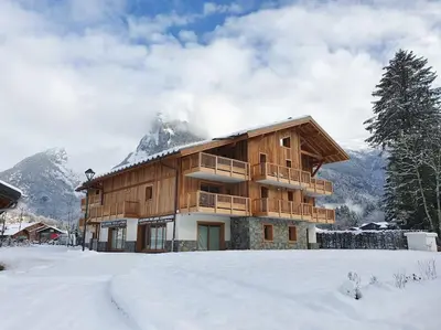 a wooden building in the snow with a mountain at Saskya 5 65m2, 2 bedrooms, next to the ski lift in Samoëns