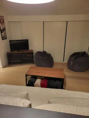 a room with a bed and a table and a tv at Duplex les Myrtilles LES CARROZ centre station in Les Carroz d'Araches