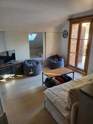 a living room with a bed and a table at Duplex les Myrtilles LES CARROZ centre station in Les Carroz d'Araches
