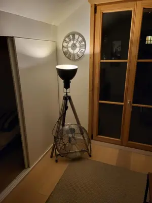 a glass fan on a tripod in a room with a clock at Duplex les Myrtilles LES CARROZ centre station in Les Carroz d'Araches