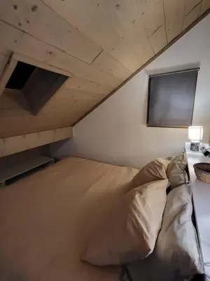 a bed in a room with a tv on the wall at Duplex les Myrtilles LES CARROZ centre station in Les Carroz d'Araches