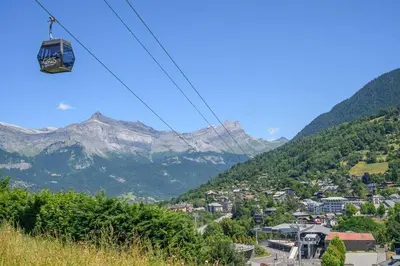 a gondola ride over a town in the mountains at L'Appartement des Pistes in Saint-Gervais-les-Bains