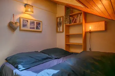 a bedroom with a bed and a book shelf at L'Appartement des Pistes in Saint-Gervais-les-Bains