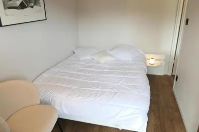 a white bed in a room with two chairs at Résidence Amethyste - Améthyste 1219 MAE-1641 in Mémontel
