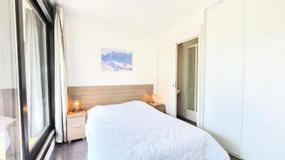 a bedroom with a bed and two tables with lamps at Résidence Les Terrasses De Veret - Appartement lumineux · Au pied des pistes · Piscine · Parking inclus · Spa MAE-1651 in Magland