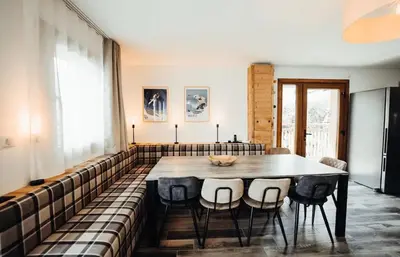 a dining room with a table and chairs at Chalet familial de 6 chambres dominant Saint-Gervais classé 4 étoiles in Saint-Gervais-les-Bains