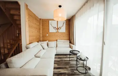 a living room with a white couch and a table at Chalet familial de 6 chambres dominant Saint-Gervais classé 4 étoiles in Saint-Gervais-les-Bains