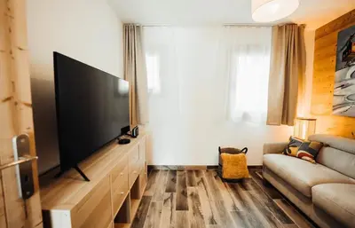 a living room with a large flat screen tv at Chalet familial de 6 chambres dominant Saint-Gervais classé 4 étoiles in Saint-Gervais-les-Bains