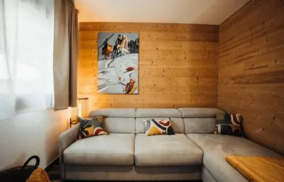 a living room with a couch in a wooden wall at Chalet familial de 6 chambres dominant Saint-Gervais classé 4 étoiles in Saint-Gervais-les-Bains