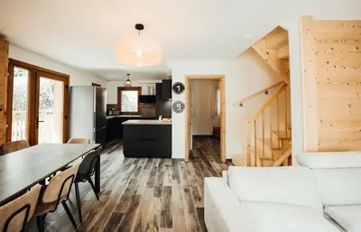 a living room with a white couch and a table at Chalet familial de 6 chambres dominant Saint-Gervais classé 4 étoiles in Saint-Gervais-les-Bains