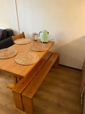 a wooden table with four pizzas and a tea kettle on it at Studio au pied des pistes in Demi-Quartier