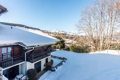 a house with snow on the roof at Studio au pied des pistes in Demi-Quartier