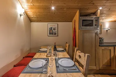a dining room with a table with chairs and a microwave at La Tramousse - - Alpes Travel - Chamonix Centre - Sleeps 6 in Chamonix-Mont-Blanc