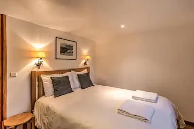 a bedroom with a bed with white sheets and pillows at La Tramousse - - Alpes Travel - Chamonix Centre - Sleeps 6 in Chamonix-Mont-Blanc