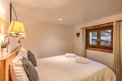 a bedroom with a bed with a lamp and a window at La Tramousse - - Alpes Travel - Chamonix Centre - Sleeps 6 in Chamonix-Mont-Blanc