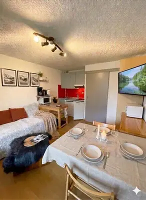 a living room with a table and a bed at Appart à la montagne navette et parking gratuit in Arâches-la-Frasse