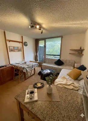 a living room with a couch and a table at Appart à la montagne navette et parking gratuit in Arâches-la-Frasse