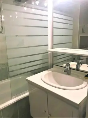 a white bathroom with a sink and a shower at Appart à la montagne navette et parking gratuit in Arâches-la-Frasse