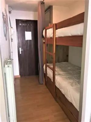 a room with two bunk beds and a door at Appart à la montagne navette et parking gratuit in Arâches-la-Frasse