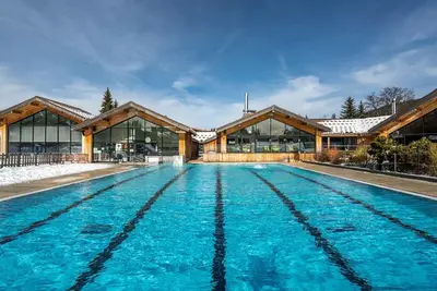 a swimming pool in front of a building at Appart à la montagne navette et parking gratuit in Arâches-la-Frasse