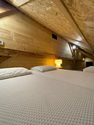 a large bed in a room with a wooden ceiling at Chalet Atmosphere Chamonix City Center Large T3 in Chamonix-Mont-Blanc