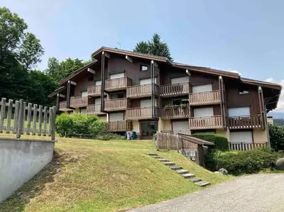a large apartment building with a fence in front of it at La marmotte: Vue Mont Blanc, terrasse, parking in Combloux