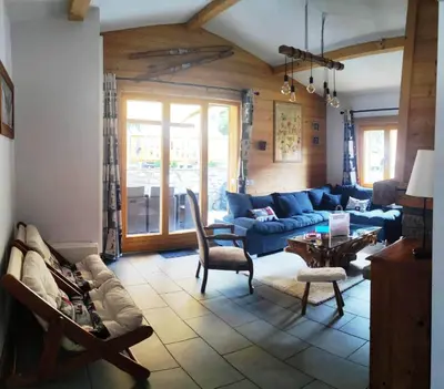 a living room with a blue couch and a table at Superbe chalet 10 personnes 5 chambres Les Houches in Les Houches