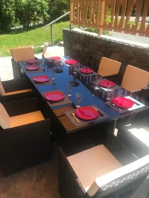 a long table with red plates and glasses on it at Superbe chalet 10 personnes 5 chambres Les Houches in Les Houches