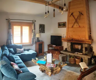 a living room with a blue couch and a fireplace at Superbe chalet 10 personnes 5 chambres Les Houches in Les Houches
