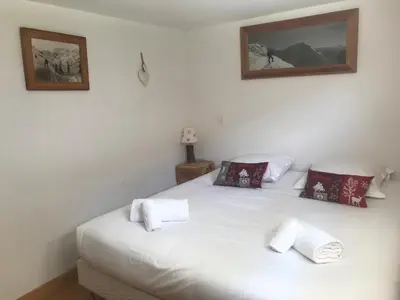 a bedroom with a white bed with two pillows at Superbe chalet 10 personnes 5 chambres Les Houches in Les Houches
