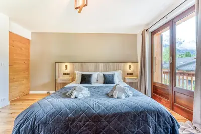 a bedroom with a large bed with two pillows at Sauna Bain Nordique Cinéma Vue Montange in Chamonix-Mont-Blanc