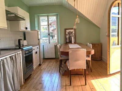 a kitchen with a wooden table and a dining room at Villa la tourelle in Saint-Gervais-les-Bains