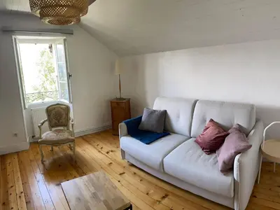 a living room with a white couch and a window at Villa la tourelle in Saint-Gervais-les-Bains