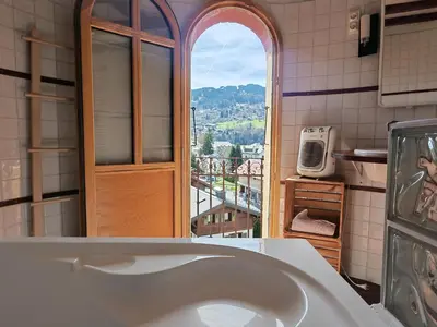 a bathroom with a white sink and a window at Villa la tourelle in Saint-Gervais-les-Bains