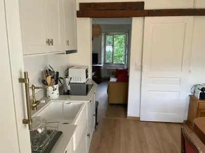 a kitchen with white cabinets and a sink and a door at Villa la tourelle in Saint-Gervais-les-Bains
