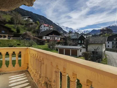 a balcony with a view of a town and mountains at Villa la tourelle in Saint-Gervais-les-Bains