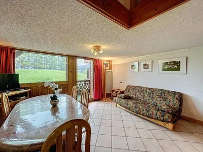 a living room with a table and a couch at Charmant 4 pièces avec terrasse face Mont Blanc, proche téléski, village et garage sécurisé - FR-1-560-133 in Combloux